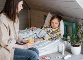 Gorączka u małego dziecka: kiedy do lekarza, a kiedy do przedszkola nie iść Mama podaje sok pomarańczowy choremu dziecku leżącemu w łóżku