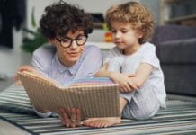 Mama z małym synem czytają razem książkę na dywanie