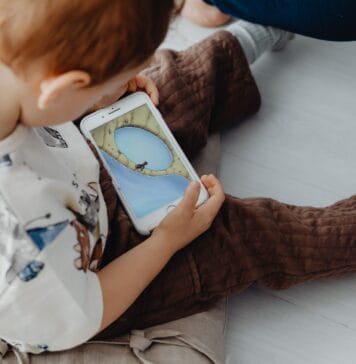 Przedszkolak gra w edukacyjną grę na smartfonie w domu