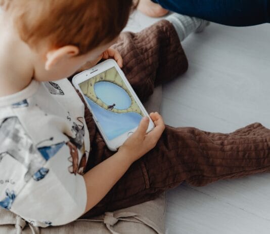 Przedszkolak gra w edukacyjną grę na smartfonie w domu